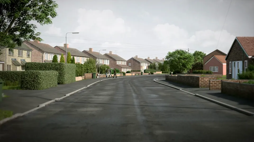A suburban residential estate road past semi-detached houses and bungalows with low brick walls, grass verges and mature trees.