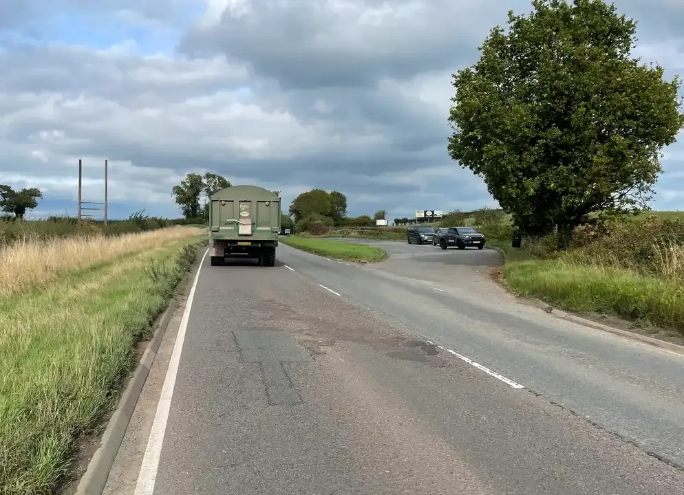 Illustration for the question: Your learner wants to overtake a long, slow-moving vehicle on a busy road. What should you teach them to do?