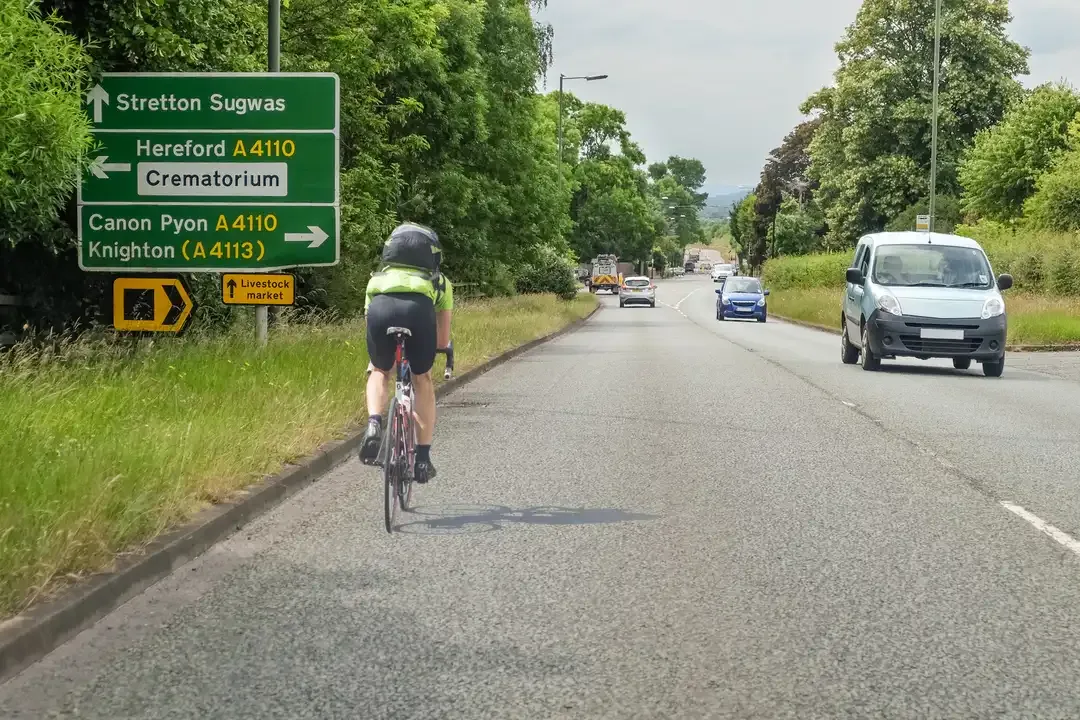 Illustration for the question: You're following a cyclist. What should you do if you wish to turn left a short distance ahead?