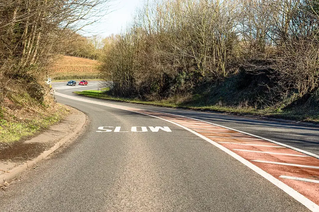 Illustration for the question: What's the reason for the hatched area along the centre of this road?